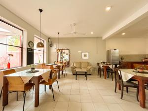 a dining room with tables and chairs and a kitchen at Maria Villa in Negombo