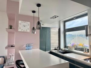 cocina con reloj en la pared y ventana en Apartament w centrum 200 m do plaży, en Międzyzdroje 10 fotos más