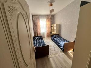 een kleine kamer met twee bedden en een deur bij Gala Guest House in Lankaran