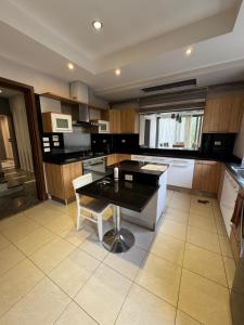 a kitchen with a table and a black counter top at villa c182 in Sheikh Zayed