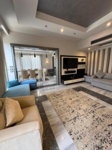 a living room with a couch and a television at villa c182 in Sheikh Zayed