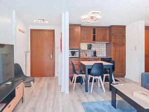 une cuisine et une salle à manger avec une table et des chaises dans l'établissement Week End 3, à Verbier 4 autres photos