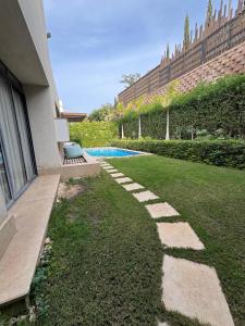 a yard with a bench and a swimming pool at villa c182 in Sheikh Zayed