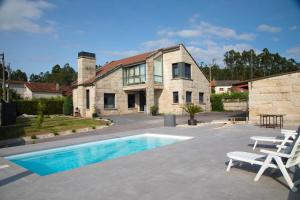 una casa con piscina di fronte a una casa di GALIHOST - Villa Gandara a Ribadumia