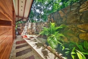 a stone wall with two plants in a yard at Beach resort playa Leona in Gigantes