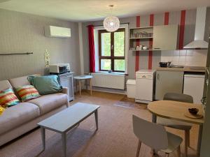 a living room with a couch and a table at Odcvl - Le Moulin Gentrey in Harsault