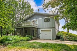 a green house with a balcony and a garage at Southhavenking- King Beds In This Home On The Lake in South Haven