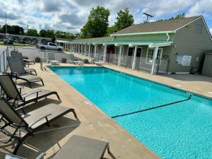 a swimming pool in front of a building with chairs at Sea Girt Lodge in Sea Girt