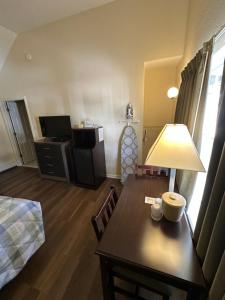 a living room with a table and a room with a bed at Sea Girt Lodge in Sea Girt