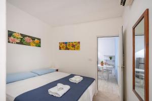 une chambre blanche avec un lit et un miroir dans l'établissement GuestHost - Casa Rosamarina Ostuni, à Rosa Marina