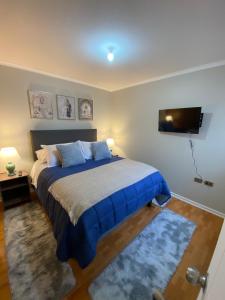 um quarto com uma cama e uma TV de tela plana em Departamento 3 domitorios, a dos cuadras de Espacio Urbano, Terminal de Buses y Sodimac em Linares