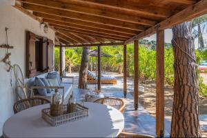 a patio with a table and chairs and a tree at Amouage Boutique Home in Skiathos