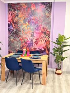 a dining room table with blue chairs in front of a painting at BOUTIQUE LUXURY City Center in Alicante +16 photos