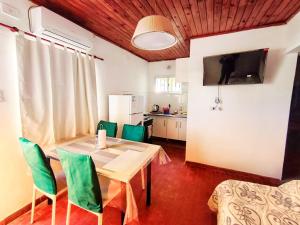 a dining room with a table and green chairs at A&C Temporarios II in Corrientes