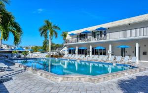 a pool in front of a hotel with chairs and umbrellas at Crescent Royale 509 in Siesta Key