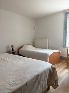 two beds in a white room with a window at Odcvl - Le Moulin Gentrey in Harsault
