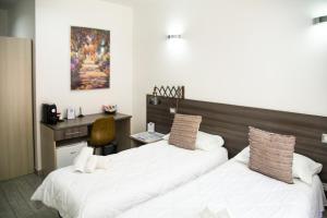 布林迪西La Maison de Monet的一间酒店房间,里面有两张床和一张桌子。