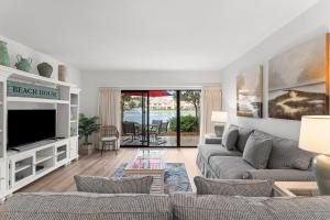Una sala de estar con un sofá y un televisor. en Beachwalk Villa 5135, en Destin