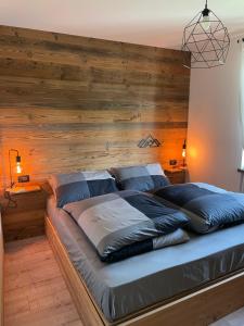 a bed in a room with a wooden wall at Casa Rizot in Madonna di Campiglio