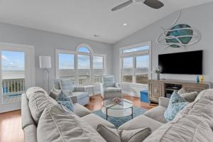 een woonkamer met een bank en een flatscreen-tv bij Ocean View Pool Waterslide Elevator & Firepit in Oak Island