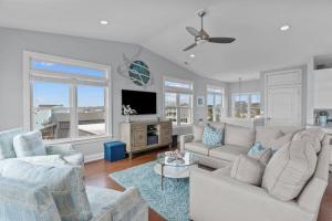 een woonkamer met twee banken en een tv bij Ocean View Pool Waterslide Elevator & Firepit in Oak Island