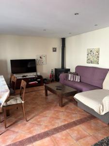 Una sala de estar con un sofá morado y una mesa. en Casa Rural Barranco, en Bielsa
