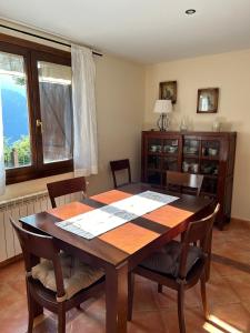 Un comedor con mesa y sillas de madera. en Casa Rural Barranco, en Bielsa