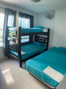 a bedroom with two bunk beds and a window at Playa Los Cocos Apat 2 y 3 in Santa Marta