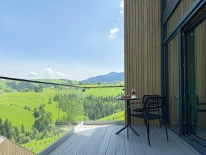 a balcony with a table and chairs and a view at Vershe in Verkhovyna