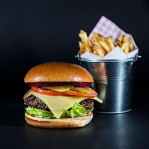 a hamburger and french fries with a basket of fries at Holiday Inn Brighton Seafront by IHG in Brighton & Hove