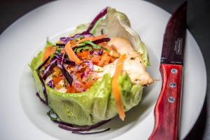 a plate of food with a salad and a knife at Holiday Inn Brighton Seafront by IHG in Brighton & Hove