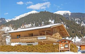 a log cabin in the snow in front of a mountain at Haus Bergmassiv in Lermoos