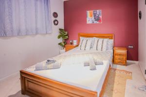 a bedroom with a large bed with a red wall at The Rina Hostel in Agadir