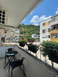 a balcony with a table and chairs and buildings at Kriss APARTMENT in Përmet