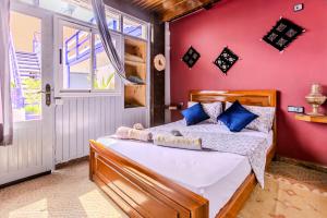 a bedroom with a bed and a red wall at The Rina Hostel in Agadir