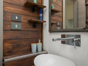a bathroom with a white sink and a wooden wall at I-Host Apartment - Omero 17 in Milan +22 photos
