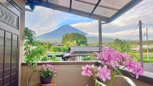 a view of a mountain from a balcony with flowers at Kitayama Fuji View House in Fujinomiya