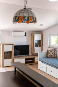 a living room with a couch and a tv at Seaview family apartments Dubrava in Pag