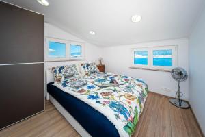 a bedroom with a bed and a fan and two windows at Seaview family apartments Dubrava in Pag