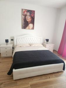 - une chambre avec un lit blanc et une couverture noire dans l'établissement Villa Patty, à Sala Bolognese