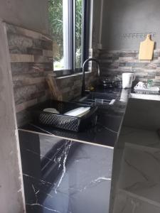 een keuken met een spoelbak en een aanrechtblad bij Ti'Kaz in Mahébourg