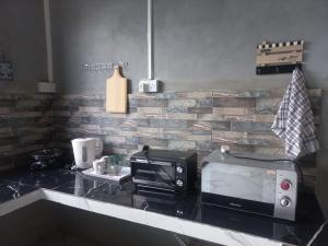 een aanrecht met een broodrooster, een oven en een magnetron bij Ti'Kaz in Mahébourg +11 foto's