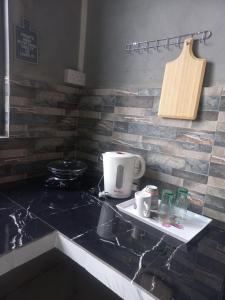 een aanrechtblad met een koffiezetapparaat op een dienblad bij Ti'Kaz in Mahébourg