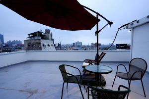 仁川市Reto House的屋顶上有一张桌子和一把椅子，还有一把遮阳伞
