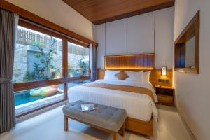 a bedroom with a bed and a large window at Joon Canggu Apartment in Canggu +36 photos
