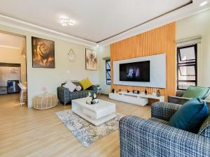a living room with two couches and a tv at Forest View Apartment in Blantyre