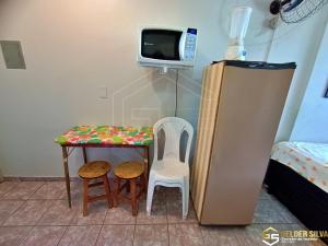 een kamer met een tafel en twee stoelen en een televisie bij Golden Thermas e Araras Apart Service CTC Centro in Caldas Novas