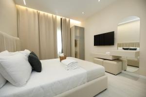 a bedroom with a white bed and a television at Villa Christianna Free Parking in Vlorë