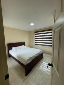 a bedroom with a large bed with a window at Casa en Urbanización La Arboleda Manta Manabí in Manta +16 photos