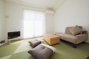 a living room with a couch and a tv at Felice Haneda in Tokyo